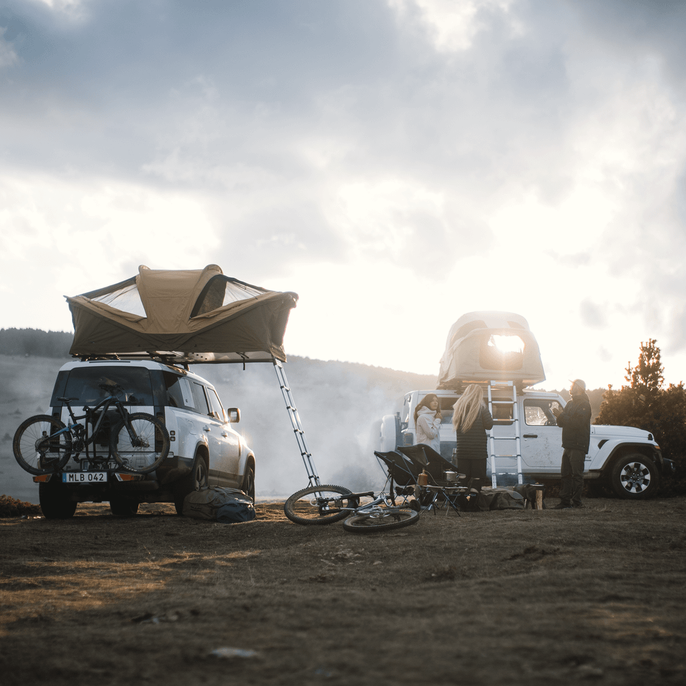 Two cars with roof top tents parked in a scenic environment