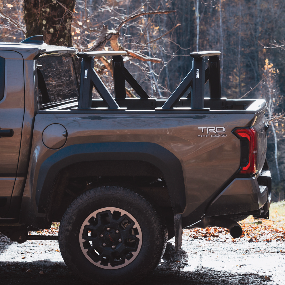 A vehicle with the Thule Xscape truck rack in an outdoors environment.