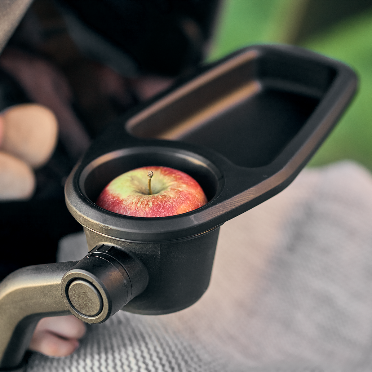 A close-up of an apple placed inside a Thule Stroller Snack Tray.