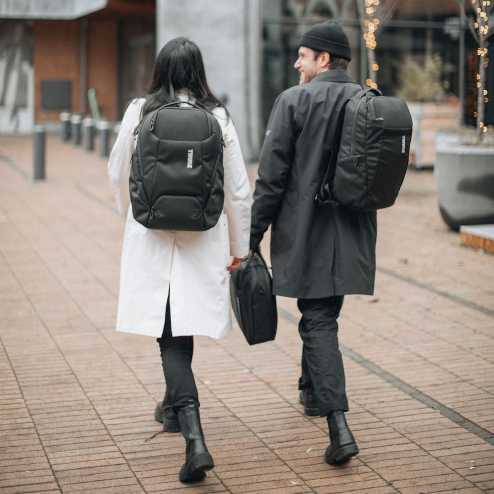 Two people walking in the city wearing Thule Accent backpacks.