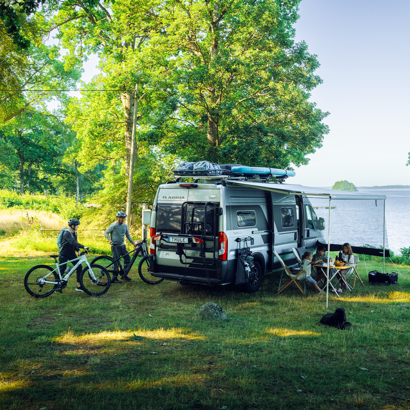 A person removes a bike from the Thule VeloTrack with the Thule Lightboard Van, demonstrating the convenient lower mounting position for effortless bike handling.
