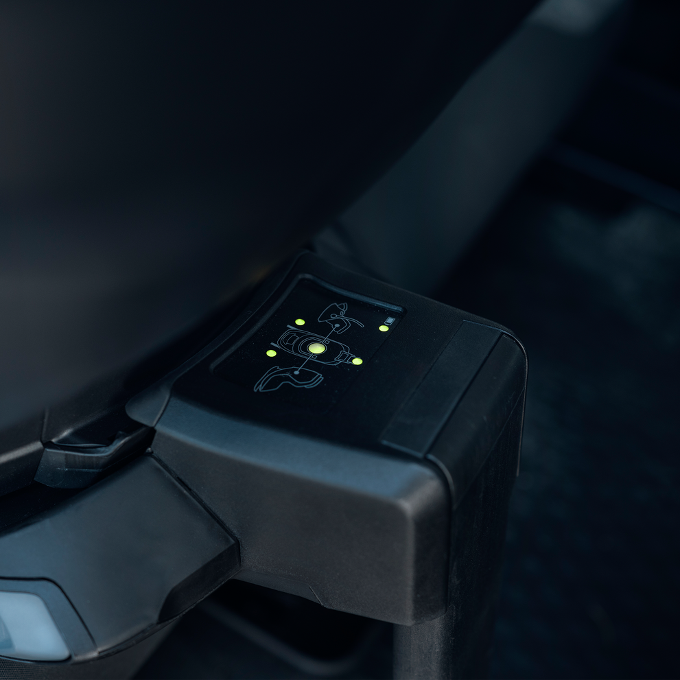 Close-up of the Thule Alfi Connect ISOFIX base installed in a vehicle with illuminated safety indicators.