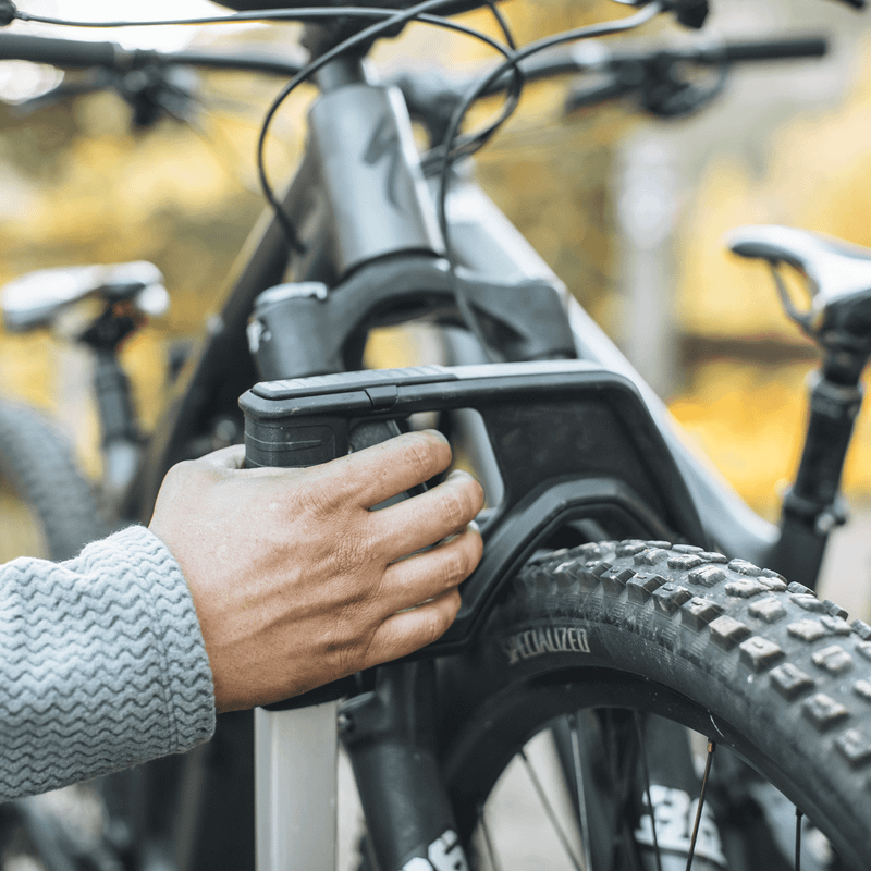 A close up of someone loading their bike into the Thule Verse bike rack.