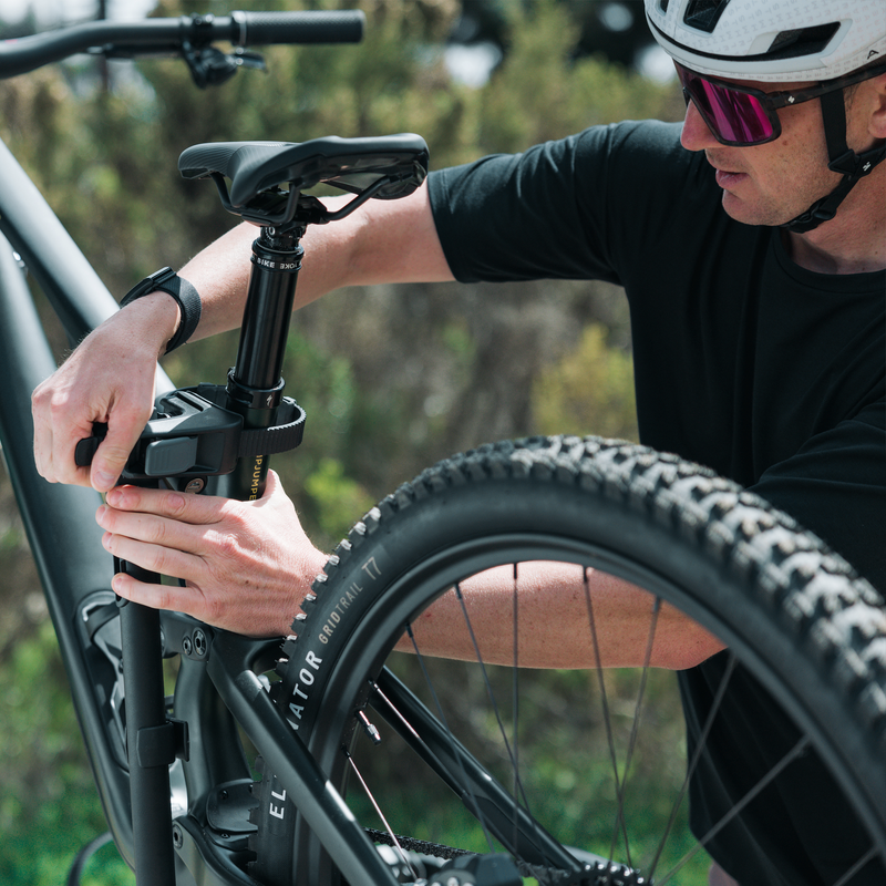 Close-up of cyclist securing a bike to the Thule OutPace hitch bike carrier using the frame clamp.
