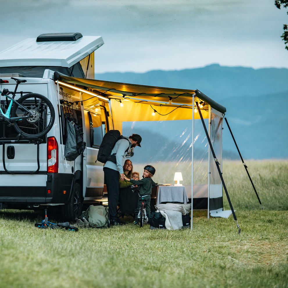 A white van overlooking the mountains and an awning with a Thule Tent LED Mounting Rail van light.