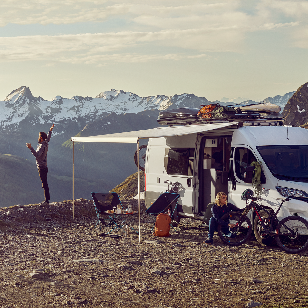 A person looking at mountains standing next to a motorhome with a  Thule Omnistor 6300 van awning.