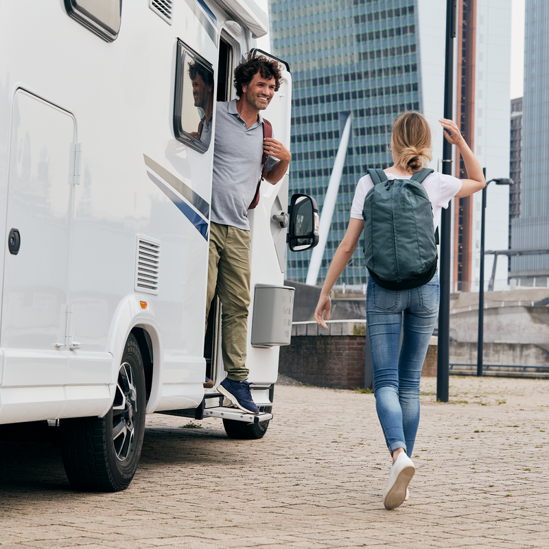 Two people stand next to a Thule Slide-Out Step Standard caravan step.