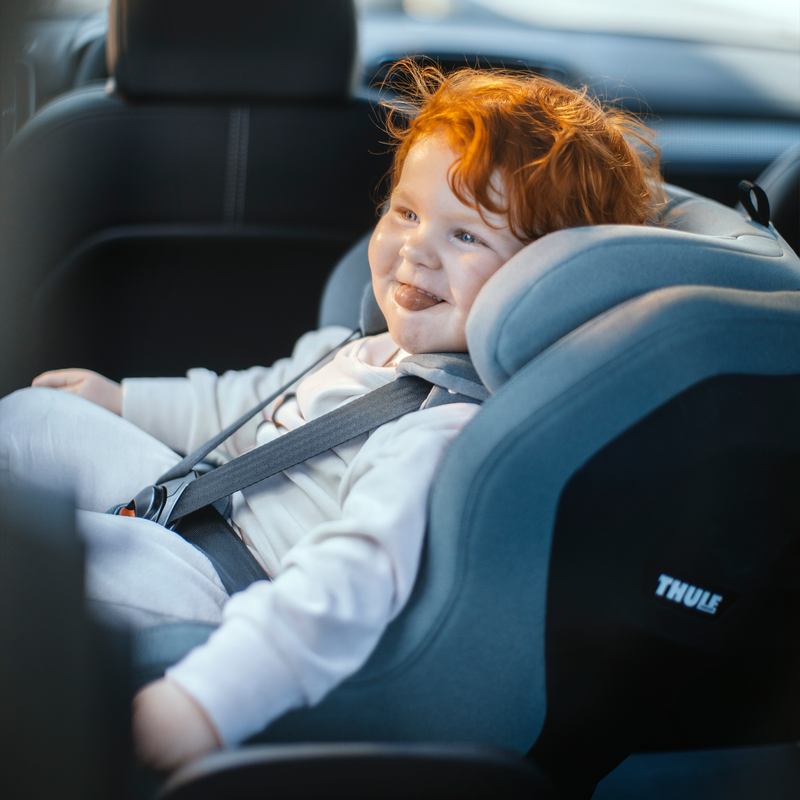 A toddler is sitting in a Thule Elm toddler car seat.