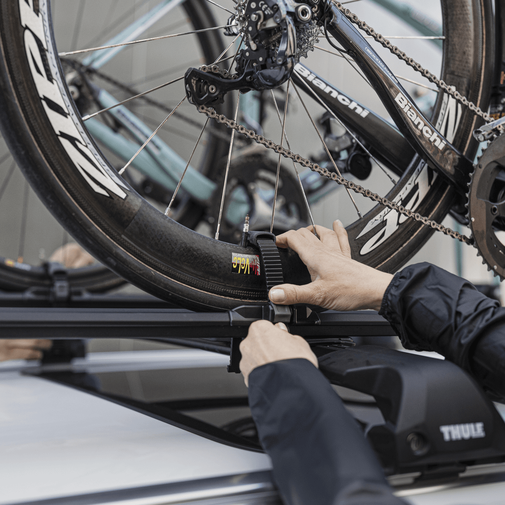 A man is mounting a bike on a car with the bike carrier Thule FastRide.