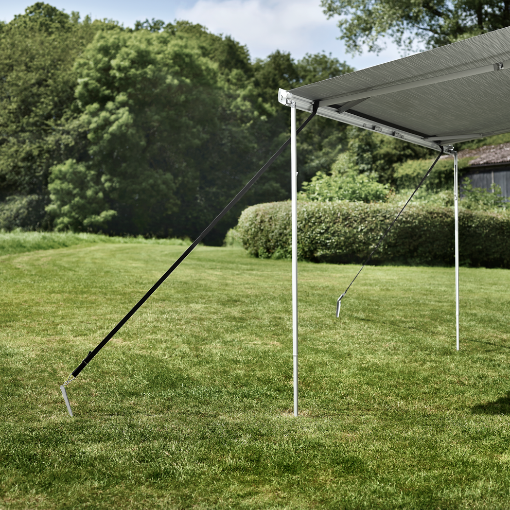 An awning attached to the grass with an RV Thule Hold Down Kit.