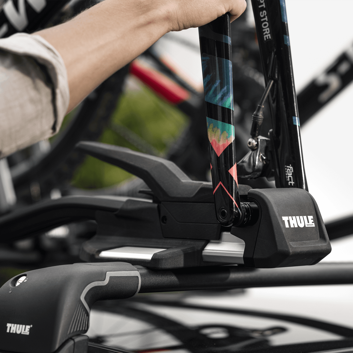 A close-up of someone installing their bikes into the Thule TopRide roof bike rack.