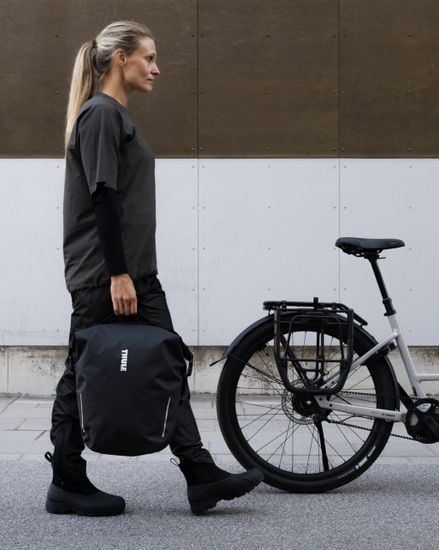Sacoche Thule Shield avec InLock 22L portée à côté d'un vélo