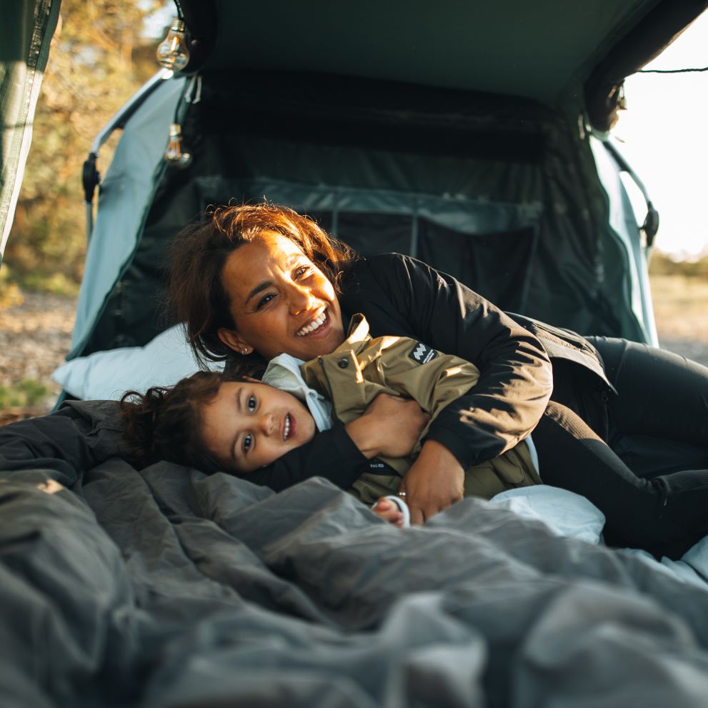 A mother and her child are cuddling in a Thule Outset.