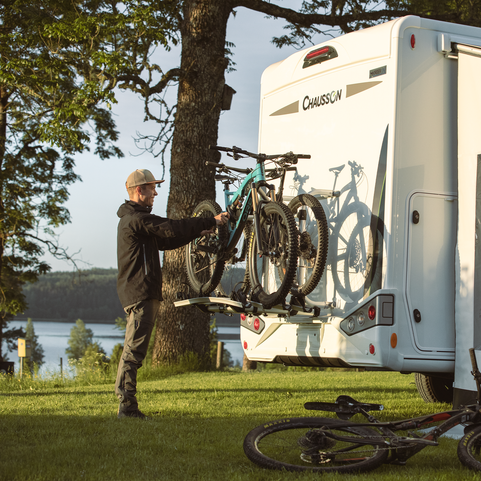 A cyclist unloads bikes from a Thule Elite G2 Standard rv bike rack.