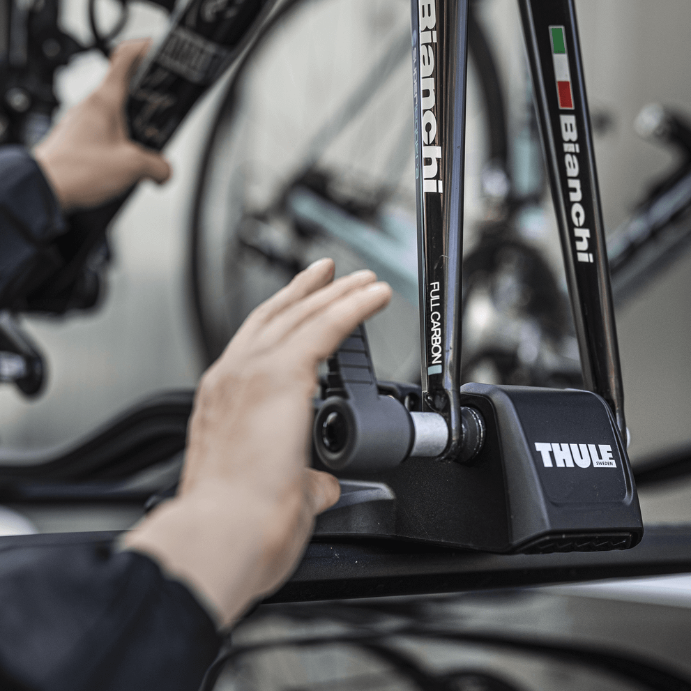 Closeup of hands mounting a bike on the bike carrier Thule FastRide.