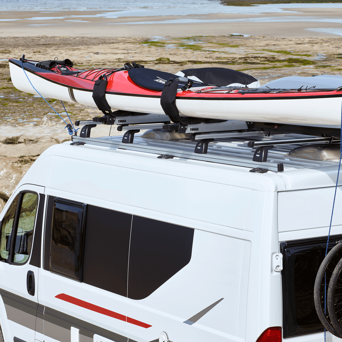 A kayak is mounted on the roof of a van with a Thule Hullavator Pro
