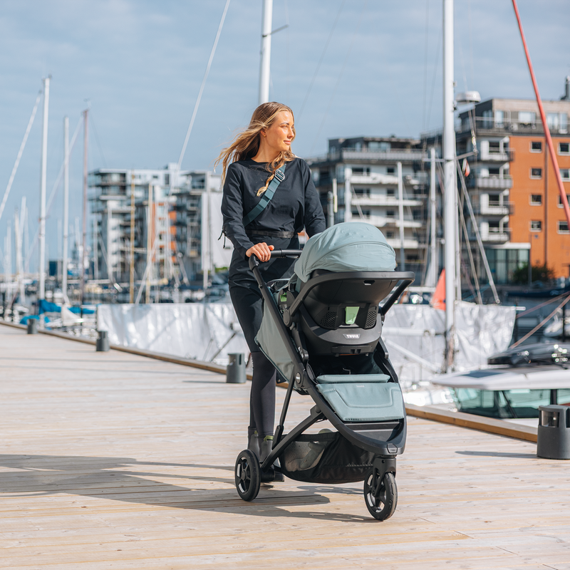 Woman pushing Thule Spring 2 with bassinet by the harbor.