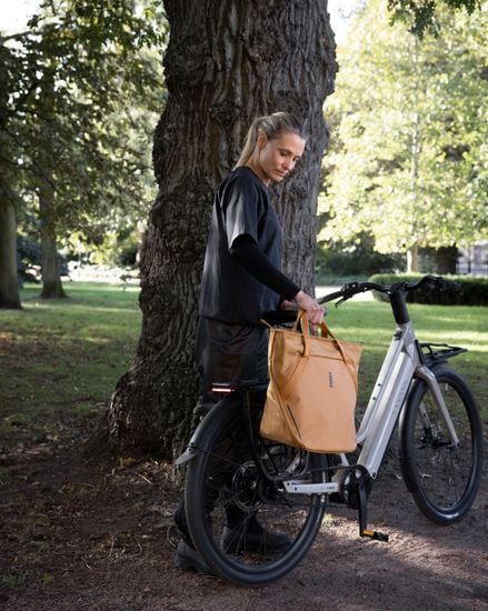 Thule Chasm tote with InLock 25L carried next to a bike
