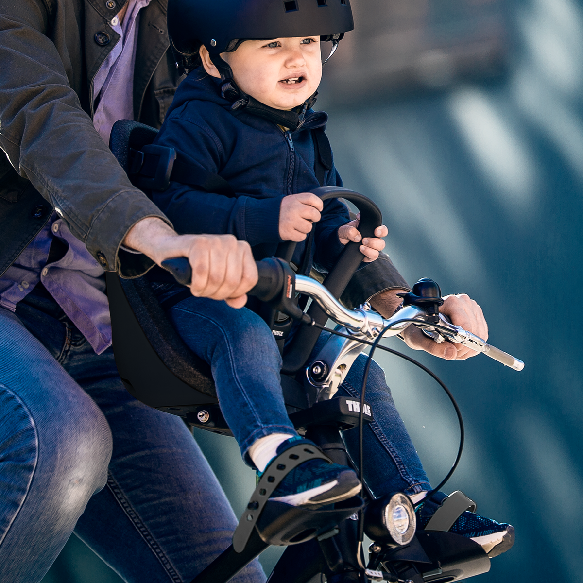 A child rides in a child bike seat using the Thule Yepp Nexxt Mini Adapter Slim Fit.