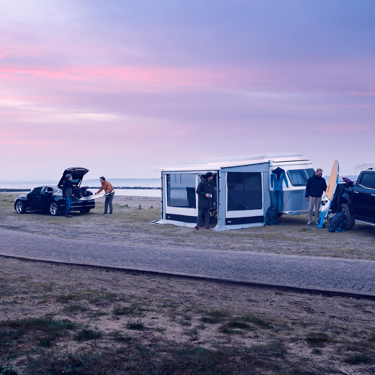 Vehicles parked by a street at the sunset with a Thule Residence G3 Eriba motorhome awning tent.