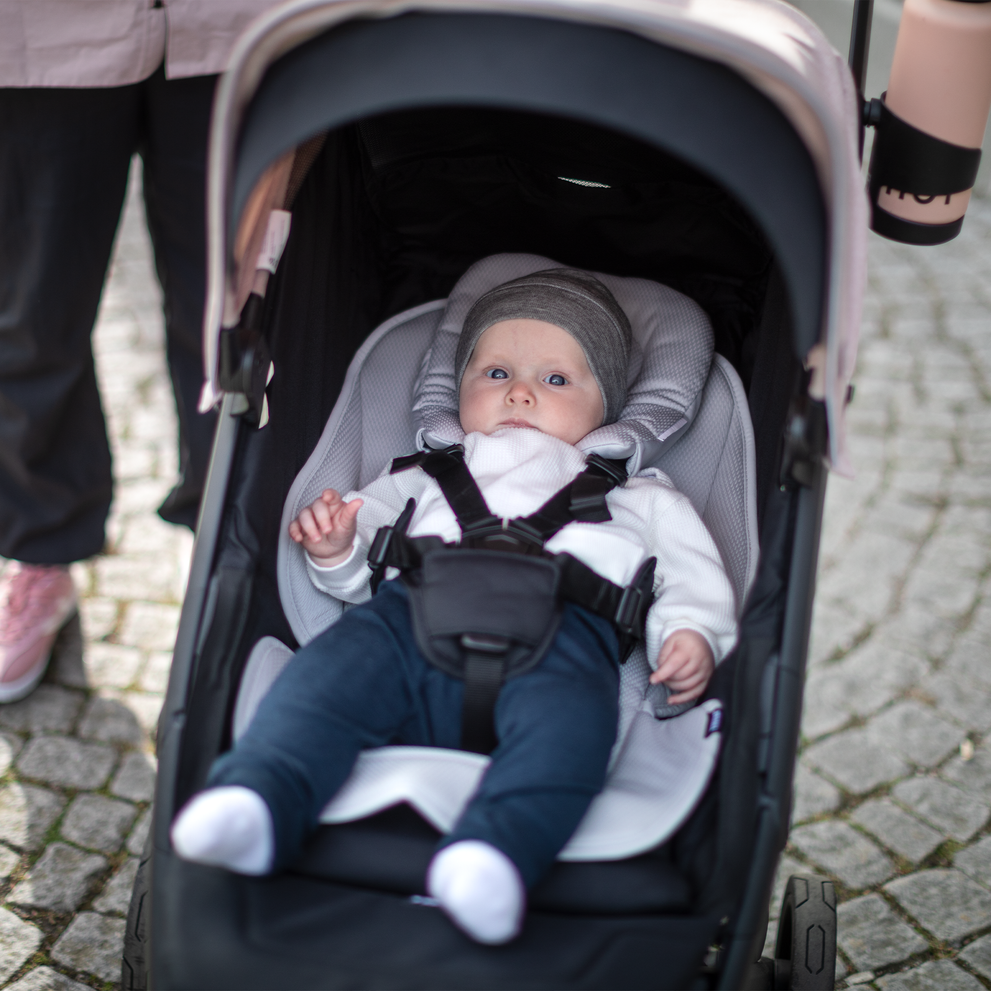 A close-up of a baby inside a Thule Newborn Inlay inside a baby stroller.