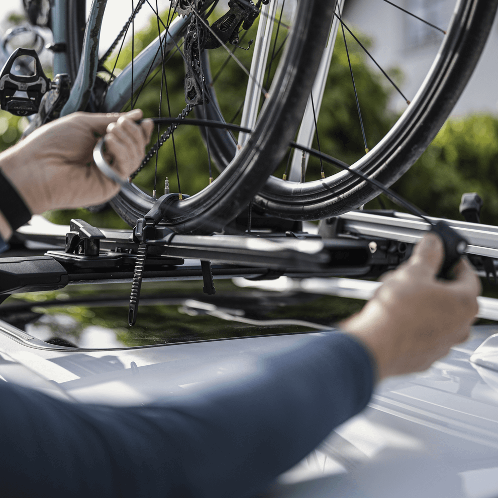 Closeup of hands mounting a bike on the bike carrier Thule FastRide.