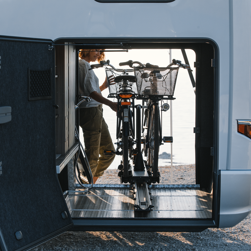 Someone unloads bikes from a Thule Veloslide Standard rv bike rack.