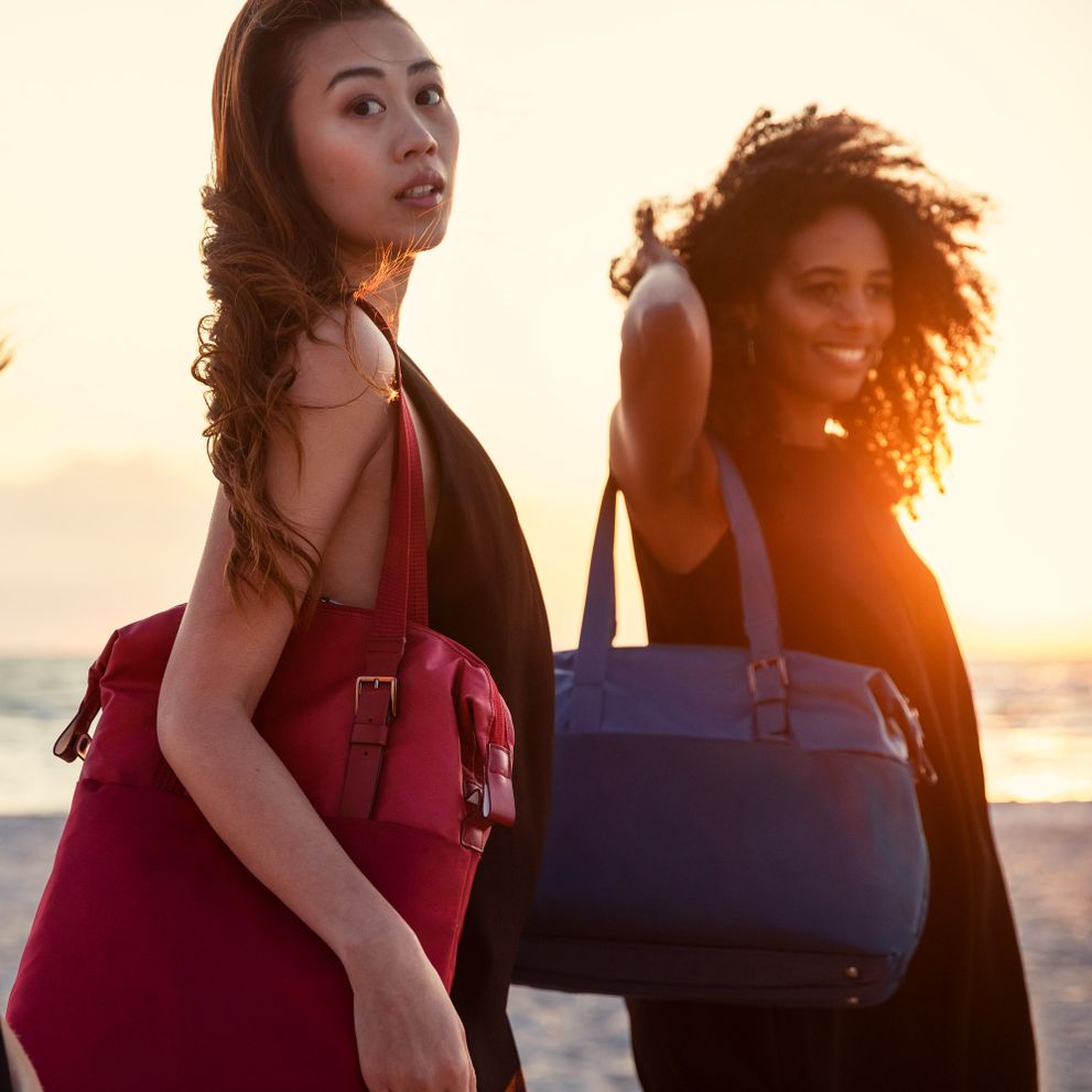 Two women carry Thule Spira Totes in the sunset.