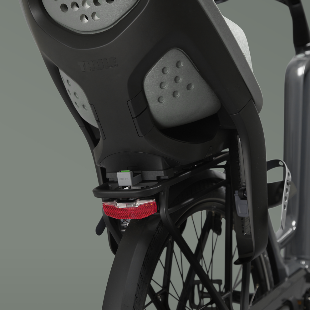 Close-up of a Thule Yepp 2 MIK HB child bike seat mounted on a bike.