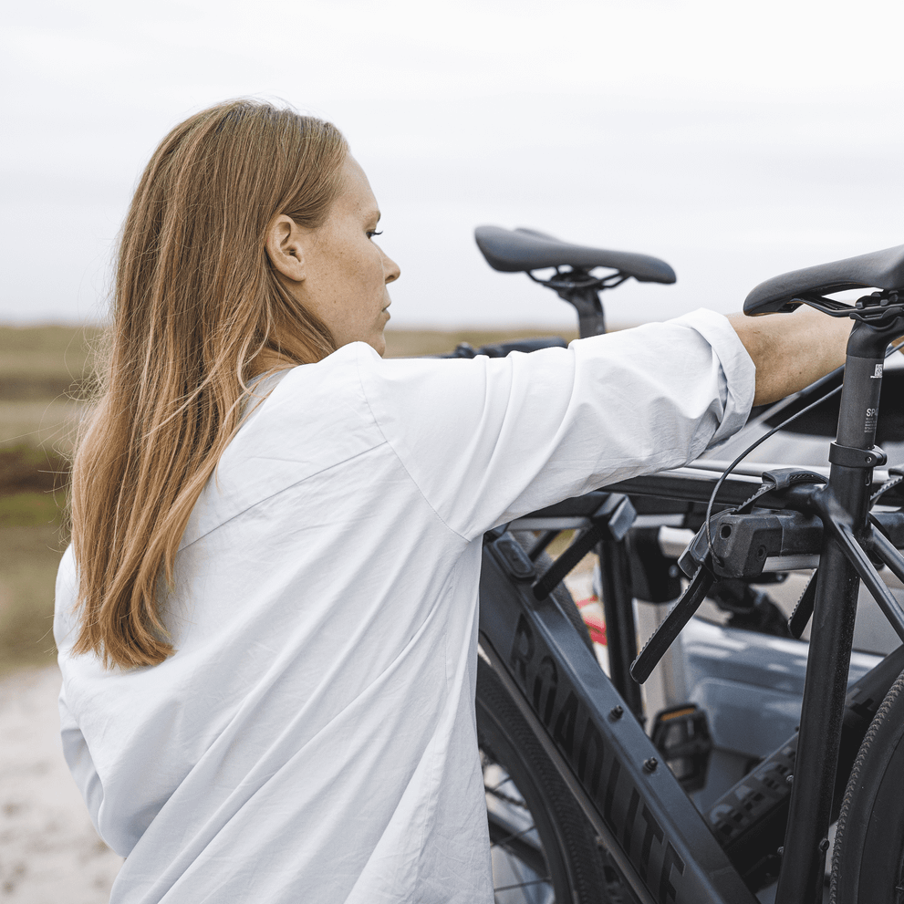 Close-up of a woman instlalling bikes into a Thule OutWay Hanging trunk bike rack.