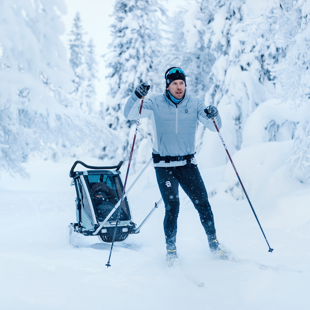 A man goes skiing with a Thule Chariot Cross and ski kit.