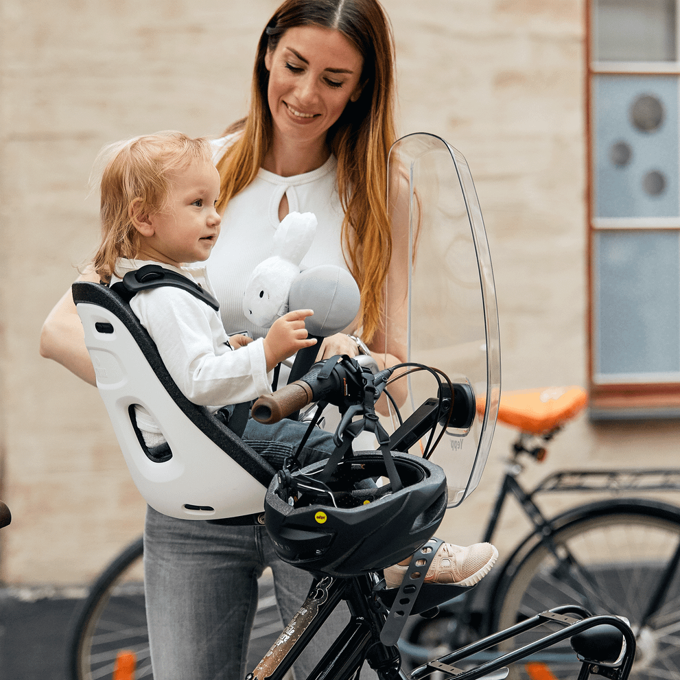 A woman tends to her child with a Thule Yepp Mini windscreen.