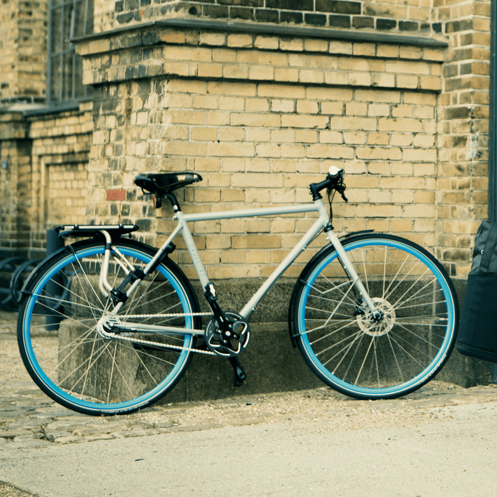 A bike with a Thule Tour rear bike rack is parked against a brick wall.