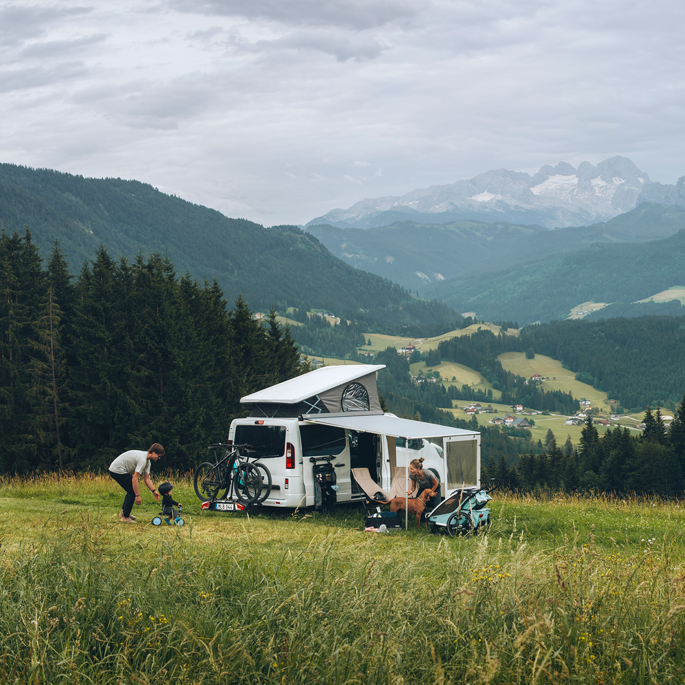 A van is parked overlooking the mountains with a Thule Rain Blocker Front awning side wall.
