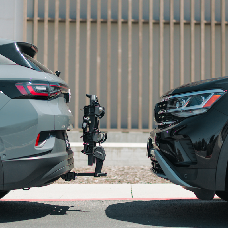 Side view of a parked car with a Thule OutPace hitch bike carrier tilted up towards the car.