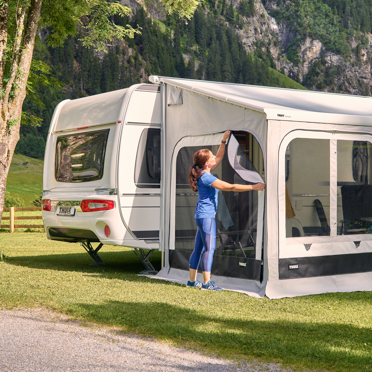 A woman inserts a Thule Mosquito - Panorama rv mosquito net into an RV.
