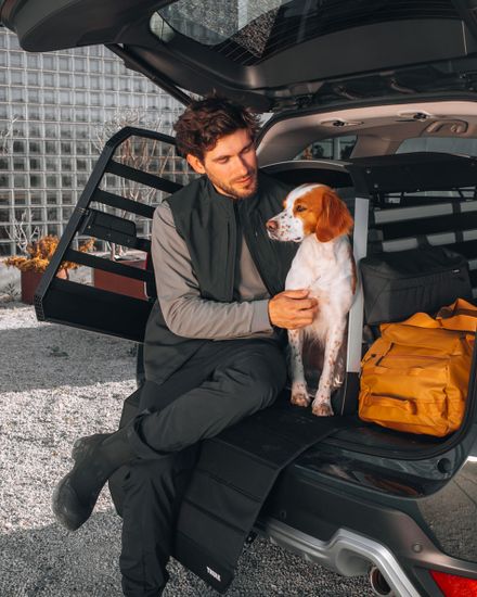 Quality design down to the last detail - A man and his dog in a dog crate sitting in the back of a car