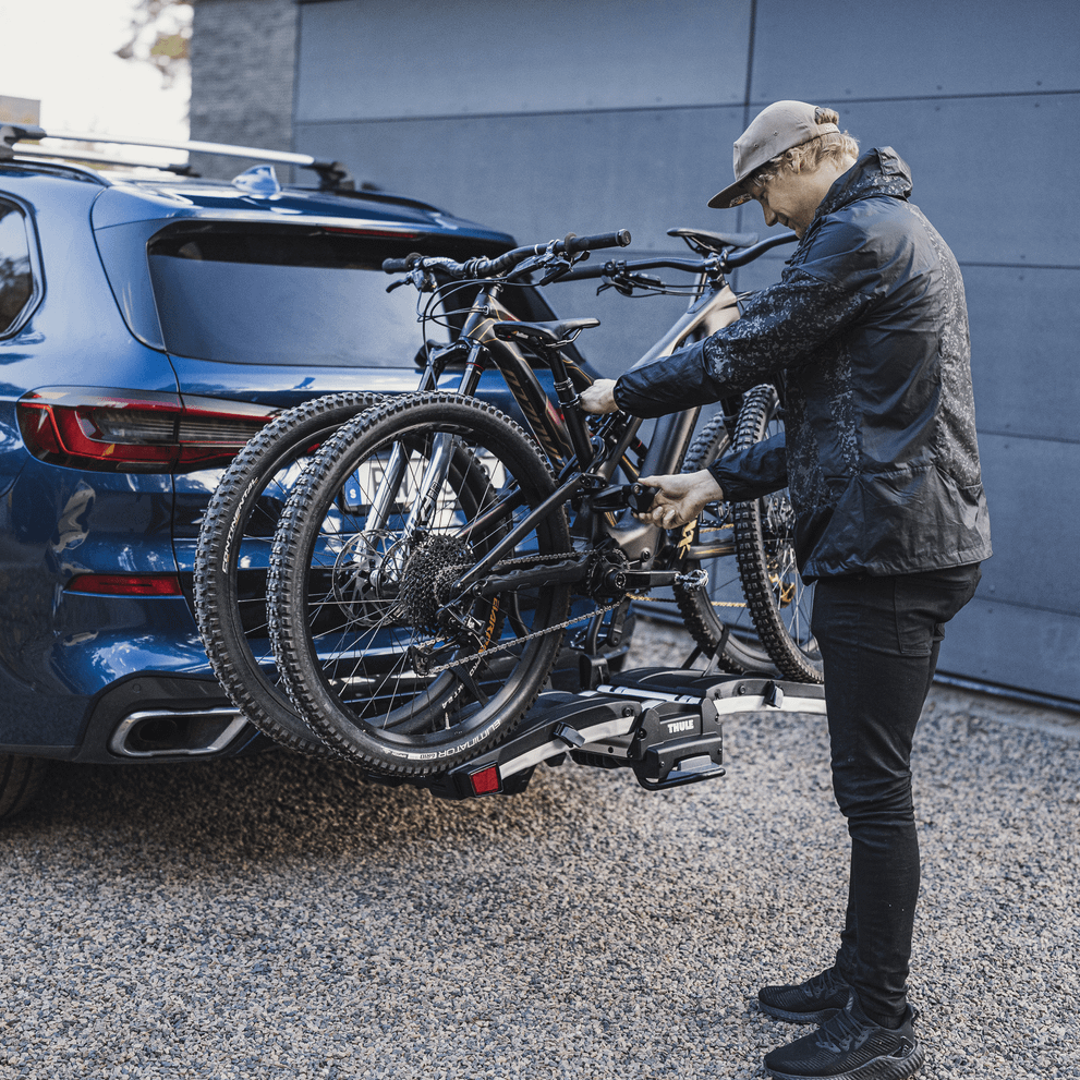 A man handles his bikes on  a car with the bike carrier Thule EasyFold XT 2