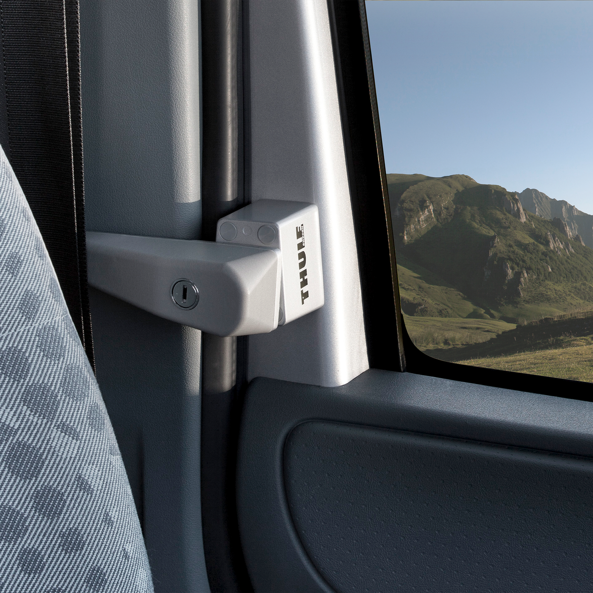 From inside a van, we can see the mountains outside the window with a Thule Cab Lock.