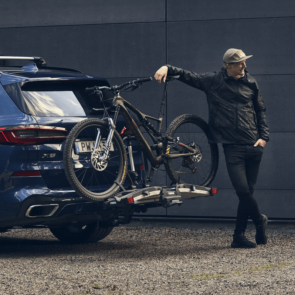 A car with the bike carrier Thule EasyFold XT 2 mounted in front of a house.