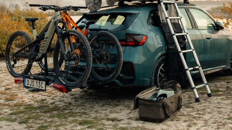 Thule Chasm gear hauler 55L junto a un coche con bicicletas y equipo