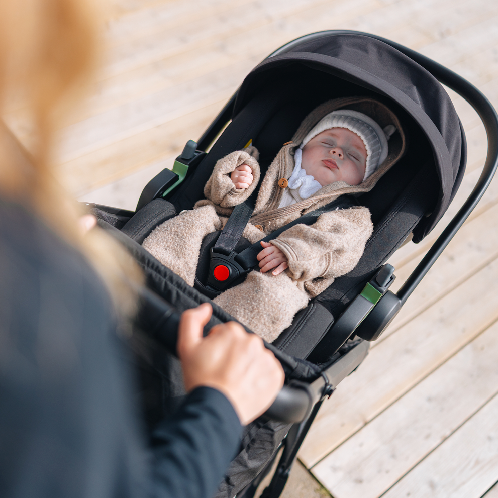 Baby in a Thule Maple infant car seat attached to a Thule Spring stroller with the Thule Spring car seat adapter for Maxi-Cosi®.