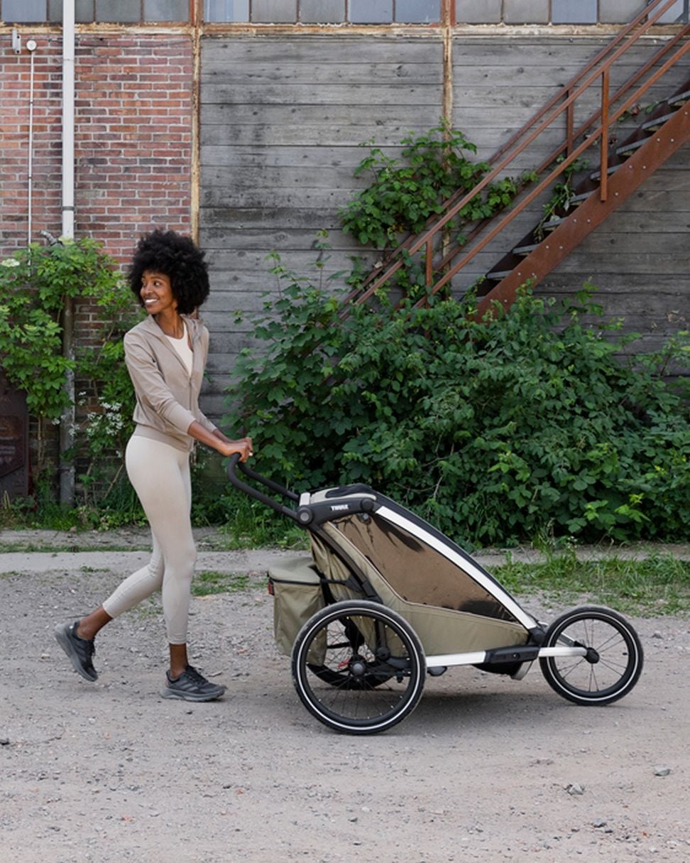 Person som skyver en sykkelhenger langs en grusvei.