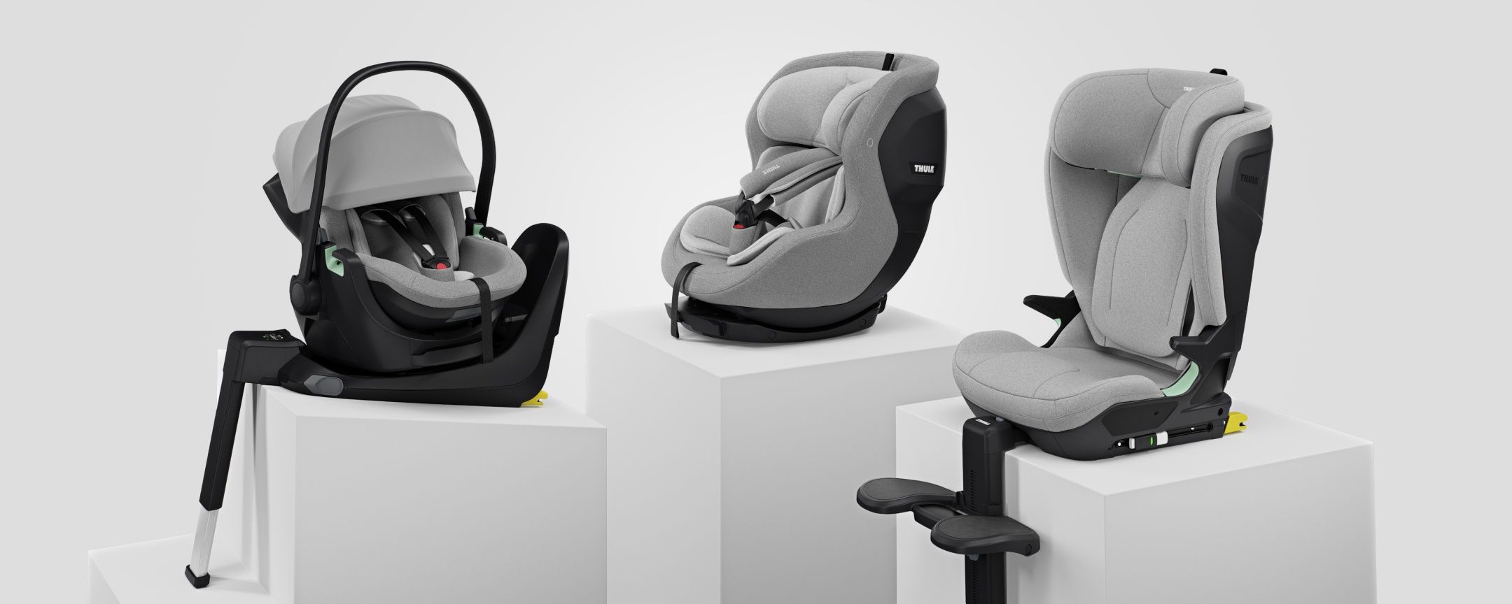 Thule Alfi -turvaistuinalusta, Thule Elm -taaperonistuin ja Thule Maple -turvakaukalo, kukin valkoisella jalustalla valkoista taustaa vasten. 