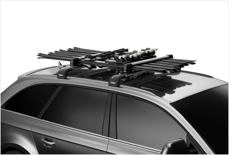 A zoomed in picture of Thule SnowPack ski racks mounted on a car roof.