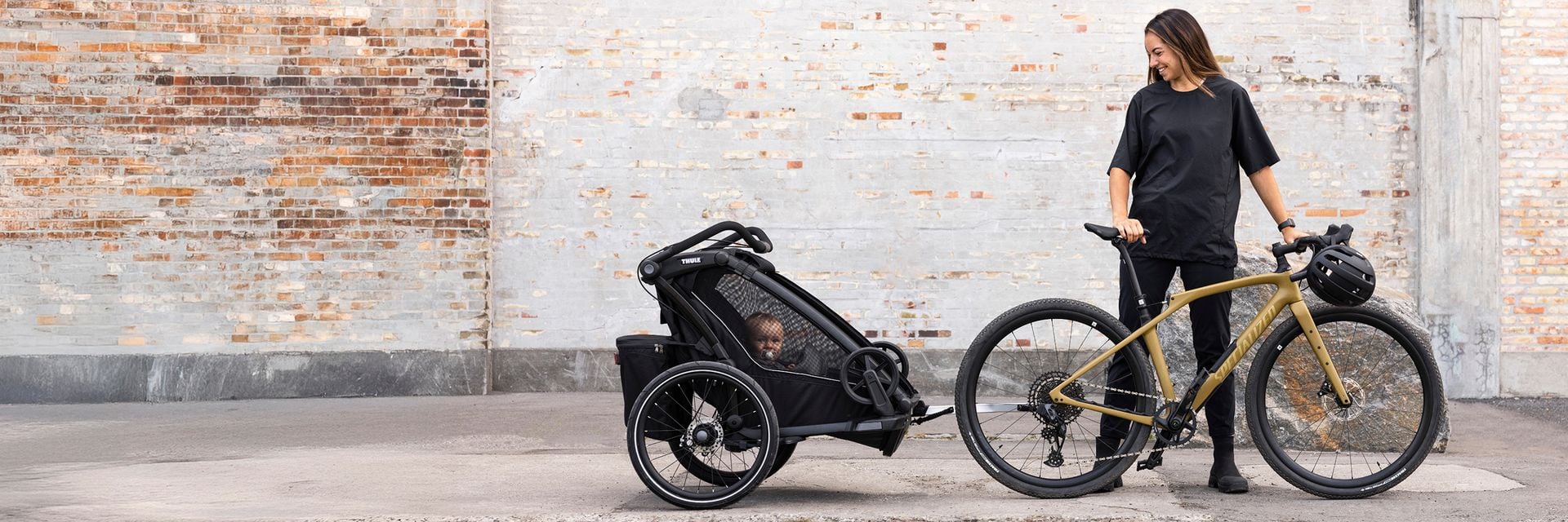 Vélo longue queue avec deux enfants à l’arrière et une remorque à vélo attachée.