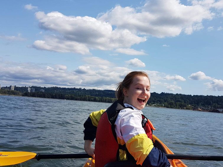 Kenzie paddles a canoe in a lake by Port Moody, close to UBC where she studied.