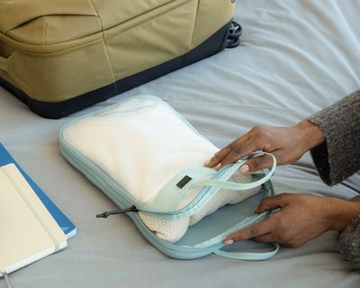 En person laster varer inn i pakkekube og pakkemappe.