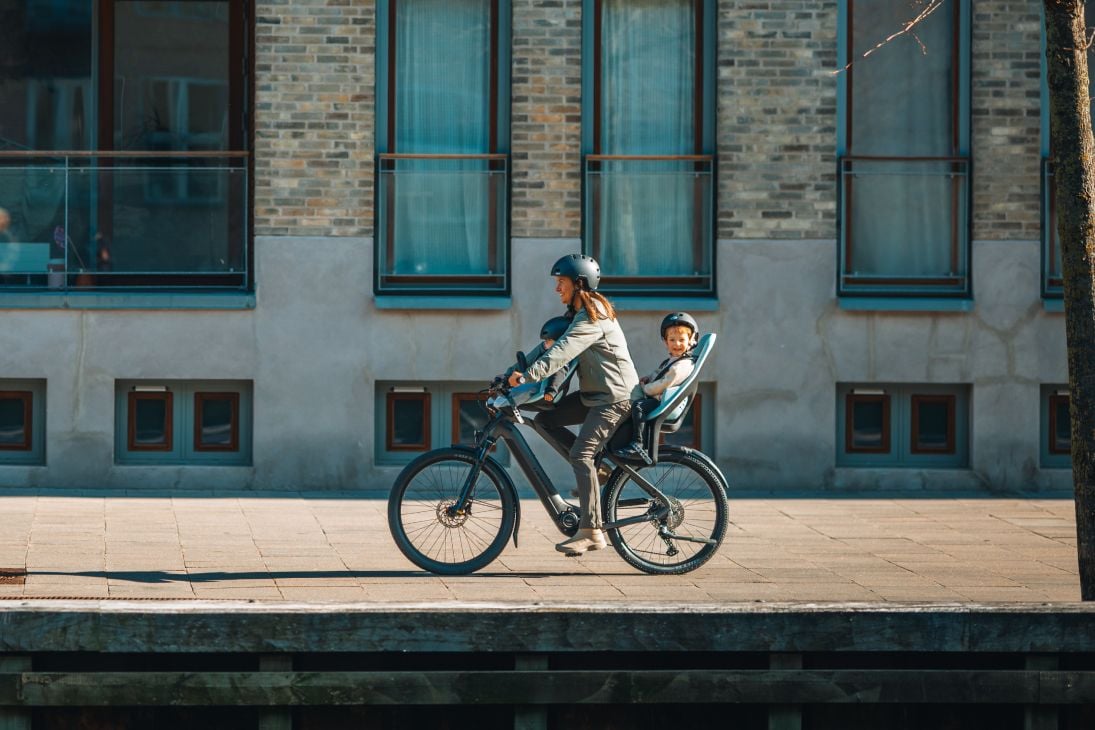 Person som cyklar med barn i både en Thule Yepp 2 mini och Thule Yepp 2.