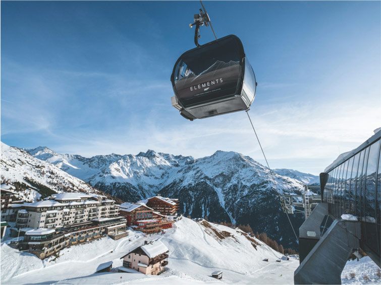 The ski lift at Sölden ski resort in Austria looks over a hotel and beautiful  mountains.